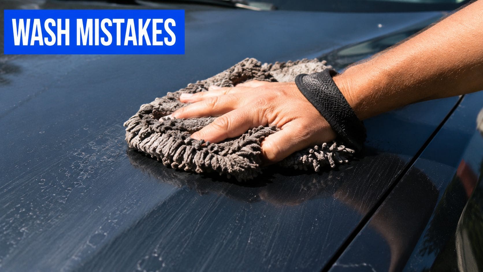 A person washing a black car hood with a microfiber mitt, demonstrating potential causes for car paint scratches.