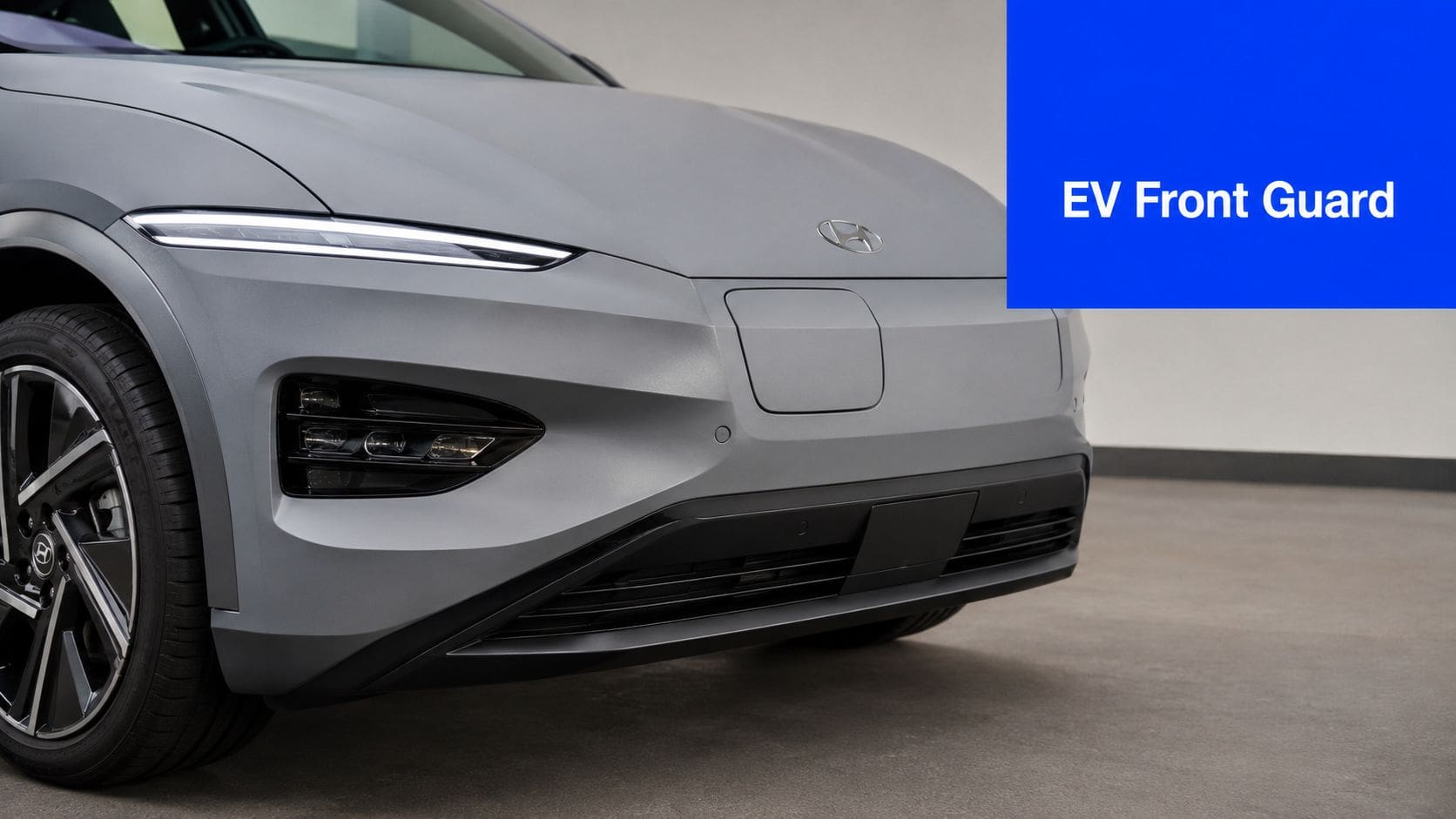 Close-up view of the front end of a gray Hyundai electric vehicle featuring protective body film.